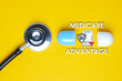 © NajmiArif - A picture of stethoscope with fake capsule, medicare advantage word, tablet, money shield and heart.