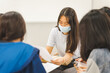© EduLife Photos - Group asian university students wear protective face mask discuss project in the classroom