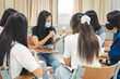 © EduLife Photos - Group asian university students wear protective face mask discuss project in the classroom
