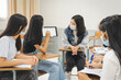 © EduLife Photos - Group asian university students wear protective face mask discuss project in the classroom