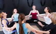 © JackF - Group of young females sitting in circle during yoga class at gym