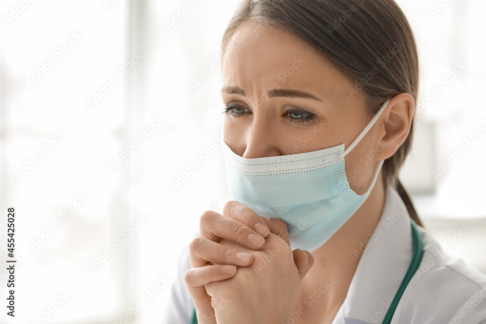 Praying female doctor in clinic