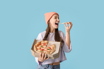 Poster - Beautiful young woman eating tasty pizza on color background