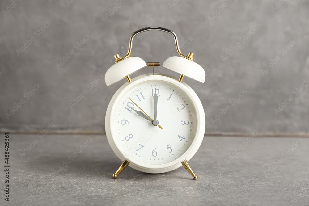 Stylish alarm clock on grunge background