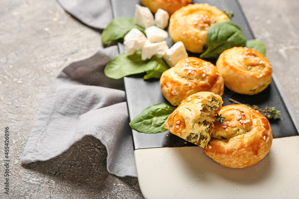 Puff pastry stuffed with spinach and feta cheese on grunge background