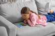 © Pixel-Shot - Cute girl watching cartoons at home