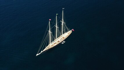 Wall Mural - View from above, stunning aerial view of a luxury sailboat sailing on a blue water during a sunny day. Costa Smeralda, Sardinia, Italy