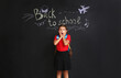 © Pixel-Shot - Surprised girl on dark background with text BACK TO SCHOOL