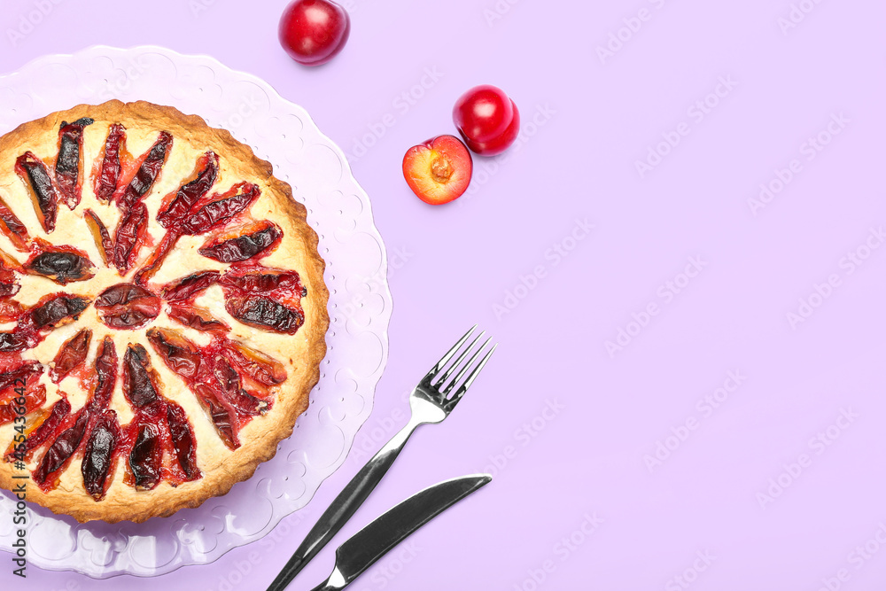 Plate with tasty plum pie on color background