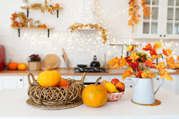 Wall Mural - colorful autumn still-life on a kitchen table. Pumpkin, bouquet of maple leaves and apples