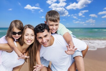 Wall Mural - Happy young family of four on the beach vacation