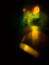 Abstract Glowing Lights Bokeh In Pink, Green, Gold, And Brown Lights On Black Room Background