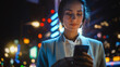 © Gorodenkoff - Beautiful Young Woman Using Smartphone Standing on the Night City Street Full of Neon Light. Portrait of Young Woman Holding Mobile Phone, Posting Social Media, Online Shopping, Texting.