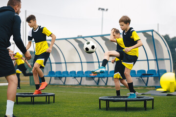 Wall Mural - Football Club Players on Training Unit. Boys Running Fast on Soccer Practice. Coach Coaching Youth Football Team. Players Kicking Balls and Standing on Trampoline. Balance Training in Soccer