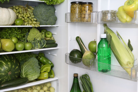 Refrigerator, content. Color diet. Organic green food. Green nutrition in fridge, refrigerator. Healthy, dietary nutrition. Green vegetables, fruits, berries. Products for diet, eating. Green color