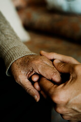 Wall Mural - young man holds the hand of an old woman