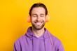 © deagreez - Photo of young man happy positive smile enjoy listen music headphones isolated over yellow color background