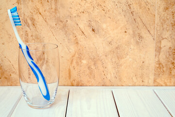 Wall Mural - Toothbrush stands in a glass on a beige background
