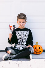 Boy In Skeleton Costume With Halloween Decorations