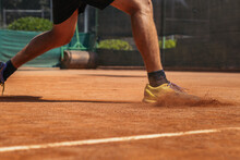 Crop Man In Sportswear Playing Tennis And Ready For Serve With Racket And Ball On Orange Field