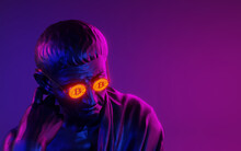Portrait Of A Seated Philosopher In Bitcoin Glasses On A Neon Background. 3d Image.