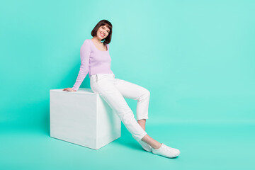 Wall Mural - Full length body size photo woman sitting in stylish outfit smiling happy isolated bright turquoise color background