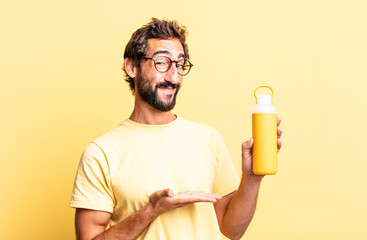 Wall Mural - expressive crazy man smiling cheerfully, feeling happy and showing a concept with a tea thermos