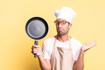 blonde handsome chef  adult man holding a pan