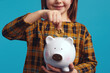 Horizontal photo of closeup anonymous girl in dress putting bitcoin coin inside piggy bank like saving money on bank account