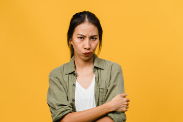 Young Asia lady with negative expression, excited screaming, crying emotional angry in casual clothing and look at camera isolated on yellow background with blank copy space. Facial expression concept