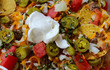 Take out nachos with beef, vegetables with dollop of sour cream