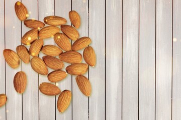 Canvas Print - Tasty brown almonds with broken on a desk