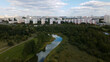 City landscape. Nearby there is a park area. Blue sky with white clouds. Aerial photography.