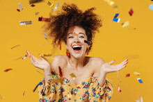 Young Happy Satisfied Excited Fun Surprised Amazed Woman 20s With Culry Hair In Casual Clothes Tossing Throwing Confetti Isolated On Plain Yellow Background Studio Portrait. People Lifestyle Concept.