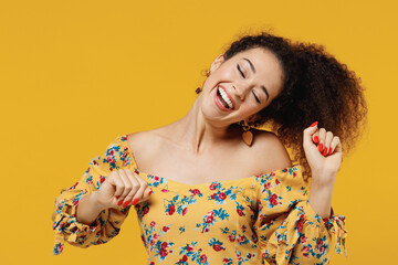 Wall Mural - Young happy relaxed beautiful european woman 20s with culry hair in casual clothes dancing have fun at party close eyes isolated on plain yellow background studio portrait People lifestyle concept