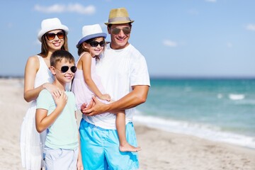 Wall Mural - Happy young family of four on the beach vacation