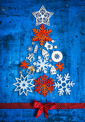 Wall Mural - Christmas and New Year concept / christmas tree from tree decorations/wooden figures of snowflakes on the blue rustic background