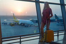 Blonde Woman Standing At The Airport And Waiting For The Plane.
