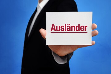 Wall Mural - Ausländer. Anwalt (Mann) mit Karte in der Hand. Text/Wort auf Schild. Hintergrund blau.