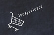 Chalk drawing of shopping cart and word inexperience on black chalboard. Concept of globalization and mass consuming