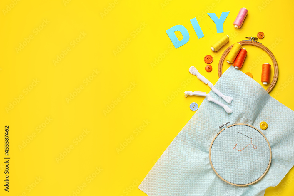 Word DIY and sewing supplies on color background