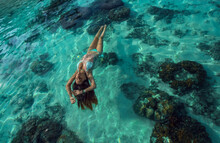 Woman In Blue Bikini Swimming In The Water