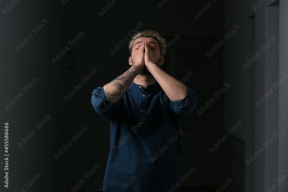 Depressed young man on dark background