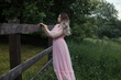 © Scopio - Woman in pink dress standing on green grass field
