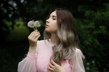 Woman In Pink Dress Holding White Dandelion