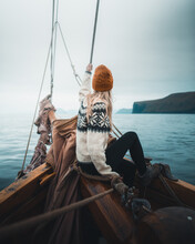 Woman Wearing Sweater Sitting On Boat On Sea