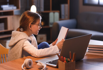 Poster - Little girl studying online at home in evening