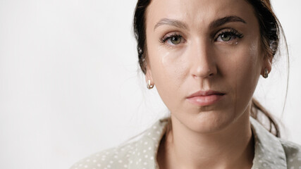 Woman is crying, tears. Portrair of woman with tears on her face on white background. Close-up