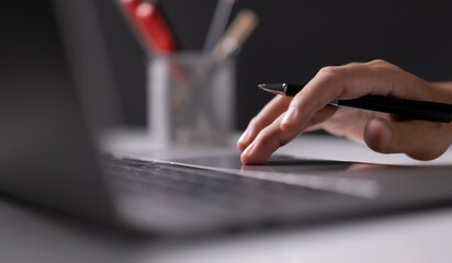 Man using laptop computer working on new project idea at desk in the office late at night with copy space