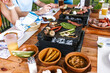 © Marcos - latin people eating Mexican food, Tacos, spicy salsa, tortillas, beer, snacks and peoples hands over wood table in a restaurant terrace in Mexico Latin America